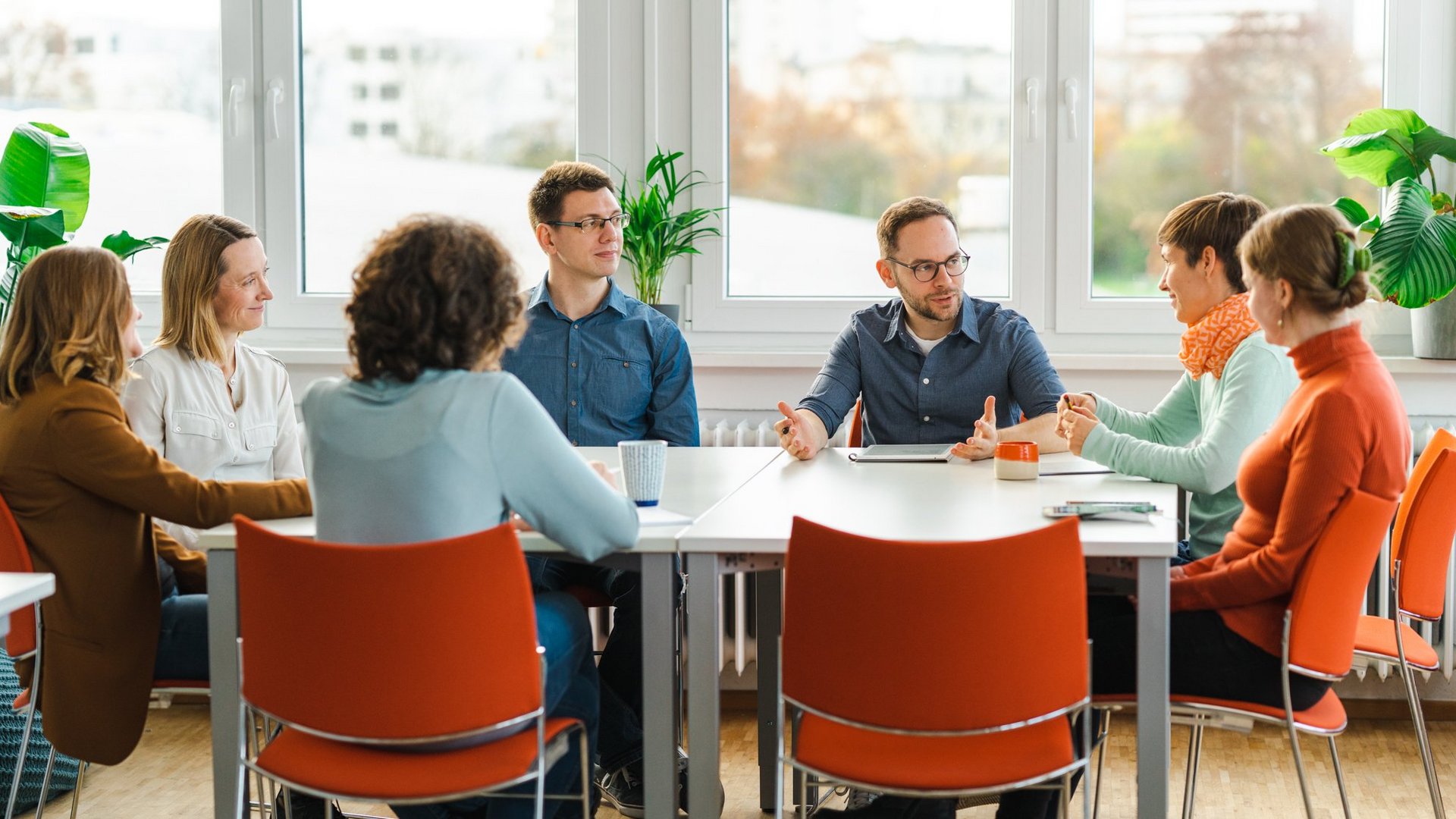 Menschen in einem Büro sitzen an einem Tisch für eine Besprechung.