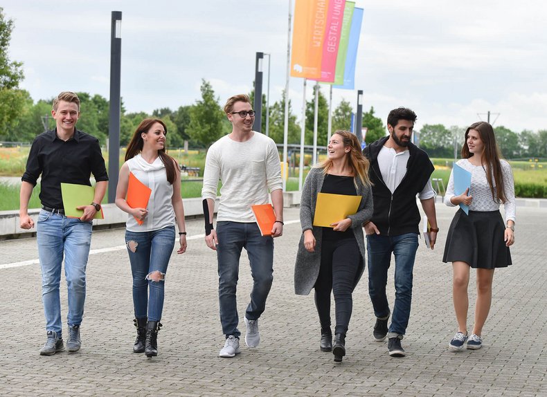 Studierende auf dem Weg zum Haupteingang am Campus